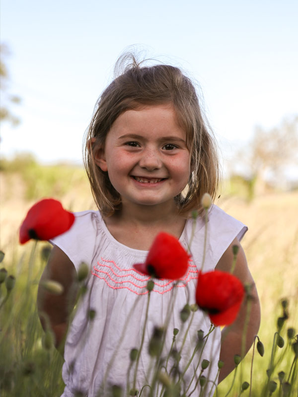 Portrait d'une petite fille dans un champ de coquelicots
