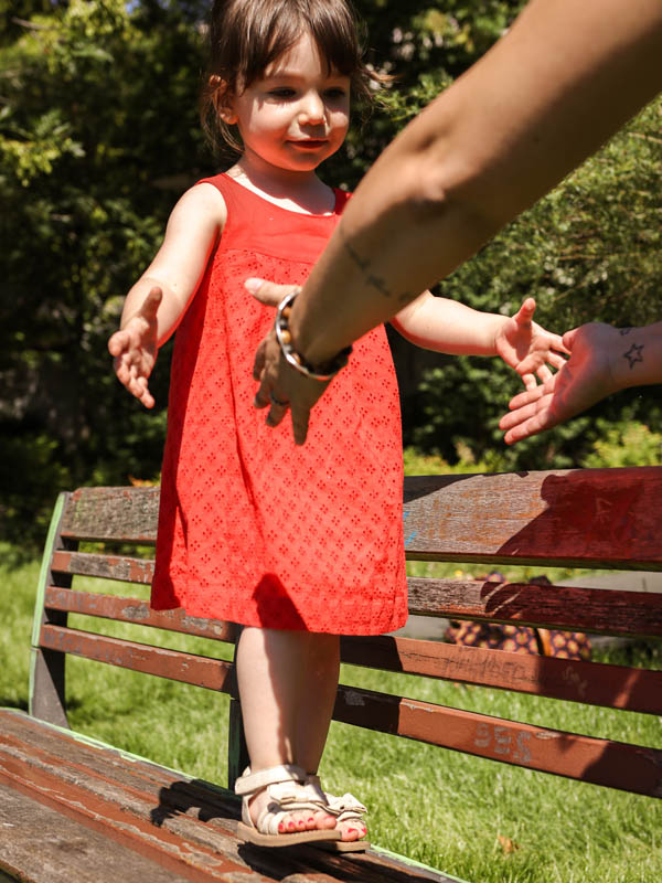 Petite fille marche sur un banc
