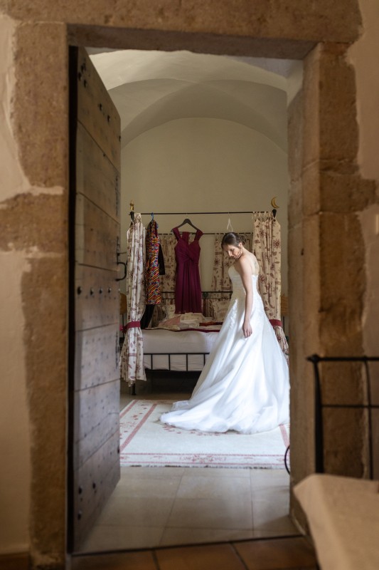 La mariée se prépare dans la chambre au plafond vouté du domaine