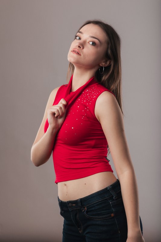 Shooting studio d'une mannequin portant un haut rouge