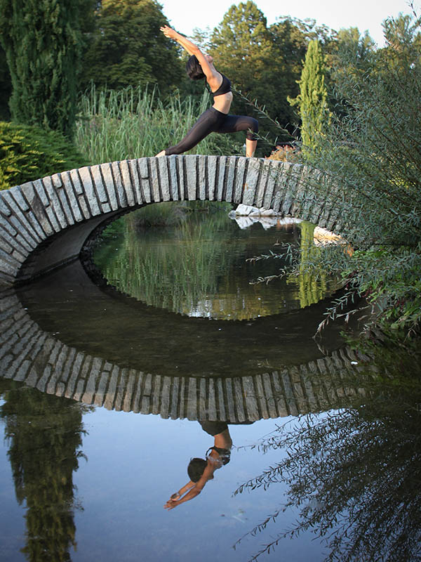 Sportive sur un petit pont de la roseraie du parc