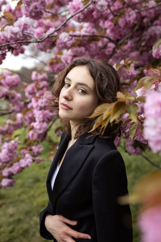 Jeune femme pose au milieu des branches fleuries d'un arbre